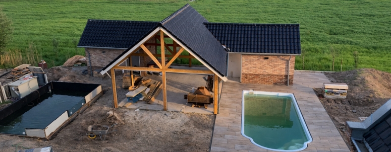 Luchtfoto bouwfase, poolhouse met dakconstructie en zwembad van bovenaf gezien